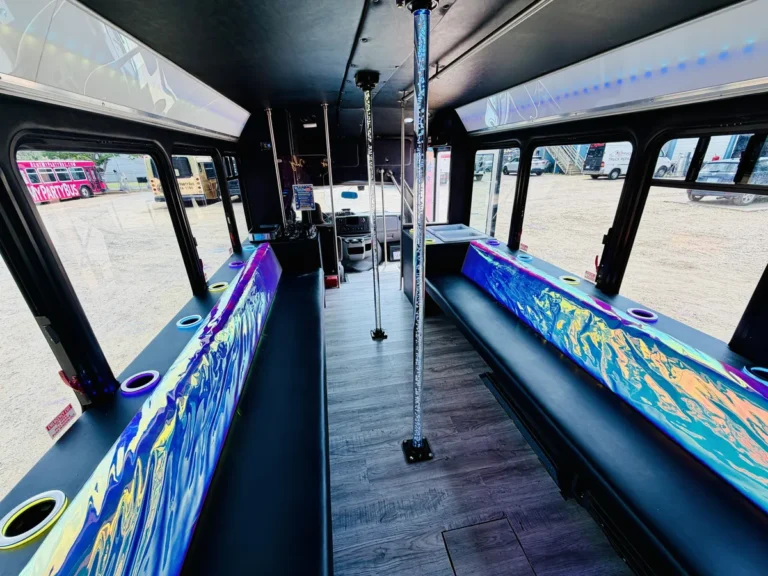Wrap-print bench seating, dance poles, and hardwood floor inside The Mini Unicorn party bus