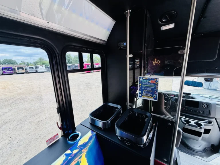 Inside The Mini Unicorn party bus looking toward the light-up bar and cooler area